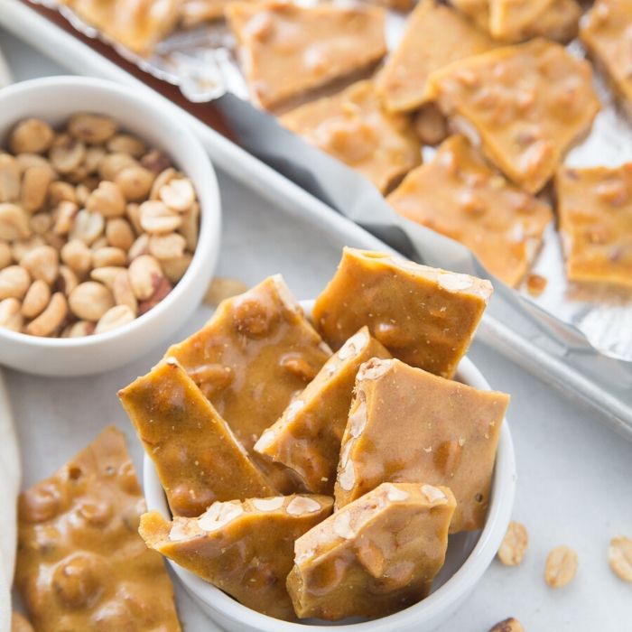 Peanut brittle is a classic holiday treat. Make this microwave peanut brittle today! Just a few ingredients, quick cook time, and a tasty Christmas recipe. #christmas #peanutbrittle #easy #microwave #rawpeanuts #cornsyrup #holiday #recipe how do you make peanut brittle