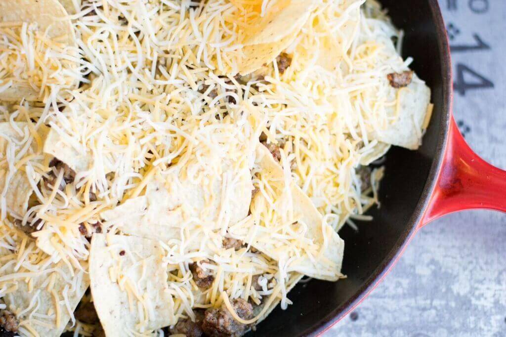 Wow your friends with this spicy game day nachos recipe. This nacho recipe is so easy to make, and loaded with all your favorite toppings. #nachos #skillet #appetizer #sausage #recipe #gameday #food #snacking #party #easy #loaded Spicy Game Day Nachos3