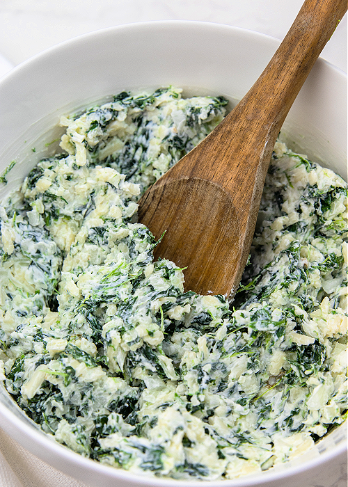 creamy spinach roll ups filling in a mixing bowl