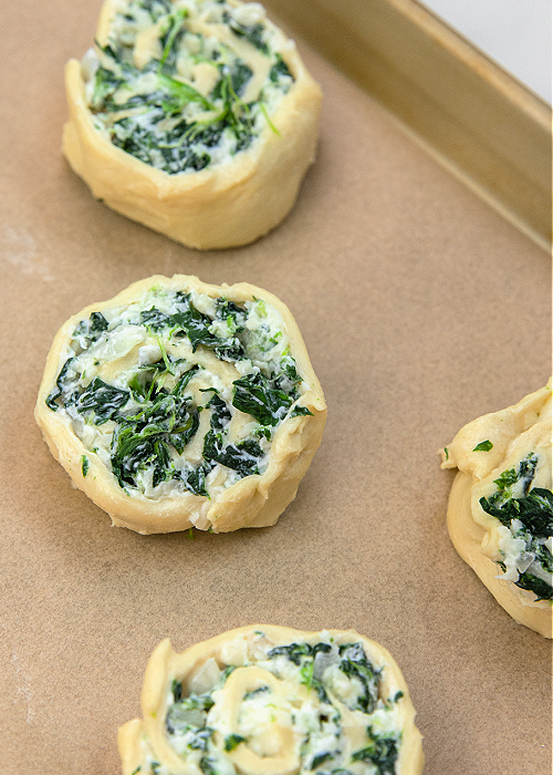 creamy spinach pin wheels on a baking sheet