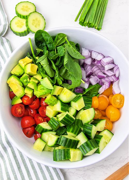 ingredients for cucumber tomato salad in a bowl