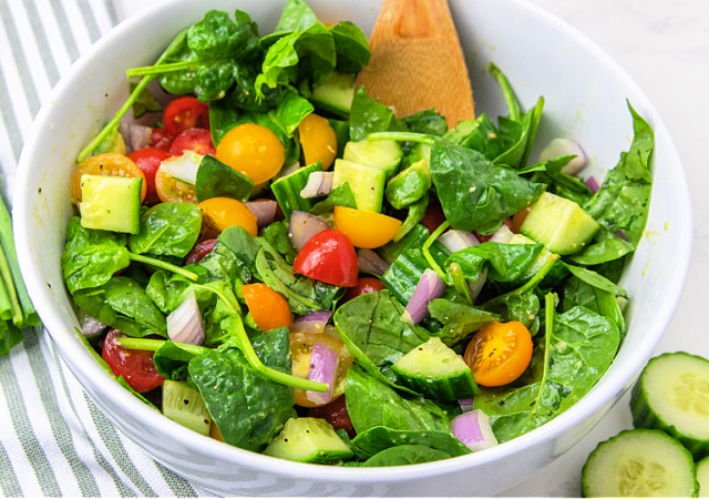 cucumber tomato salad in a white serving bowl
