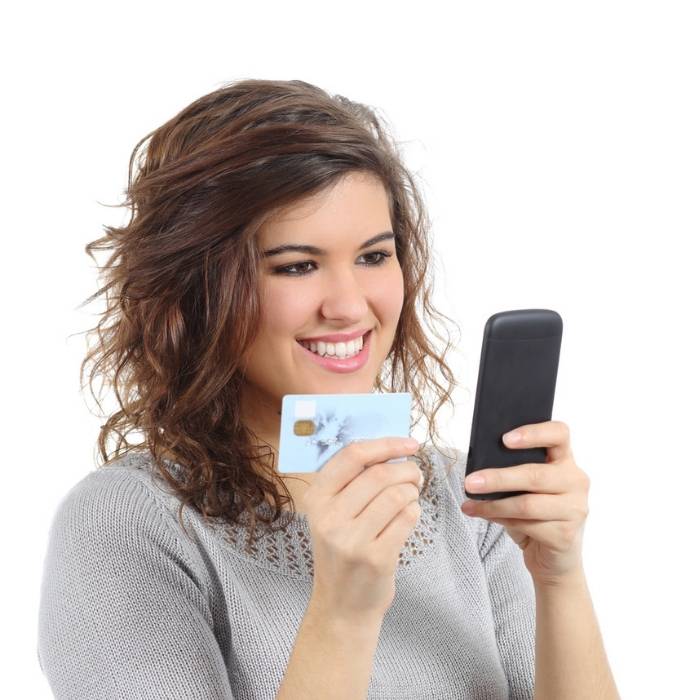 girl holding credit card looking at phone