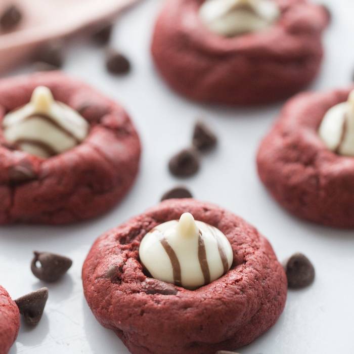I have a love affair with anything red velvet, and this red velvet cookie recipe is a must make this Valentine's Day. It is topped with a Hugs Hershey's Kiss. #cookies #valentinesday #redvelvet #easy #recipe #best #withhersheykiss #gooey #tasty red velvet cookies on table