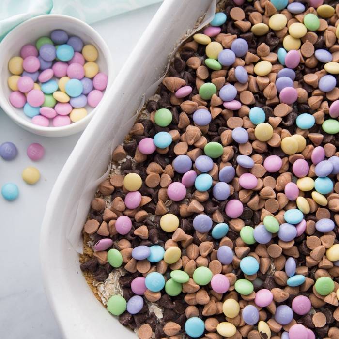 EASY M&M Easter Cookie Bars are the perfect dessert for Easter. Colorful, bright, and delicious down to the last crumbs. Make these cookie bars today. #cookiebar #Easter #dessert #easy #potluck #layeredbars #magicbars Easter cookie bars