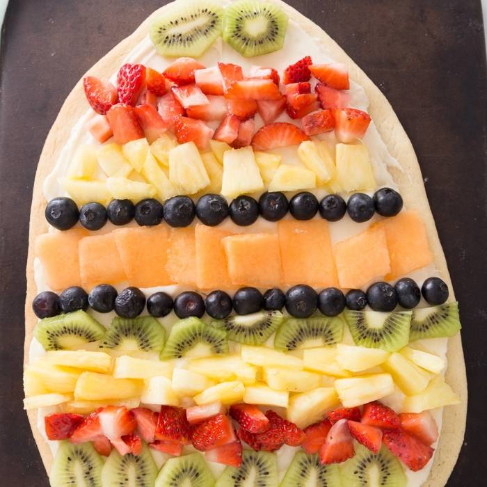 EASY Easter Egg fruit pizza is a must make. A sugar cookie crust that has a layer of cream cheese frosting, and topped with fresh fruit. #easter #dessert #easy #freshfruit #sugarcookie #creamcheese #fruitpizza easter egg fruit pizza