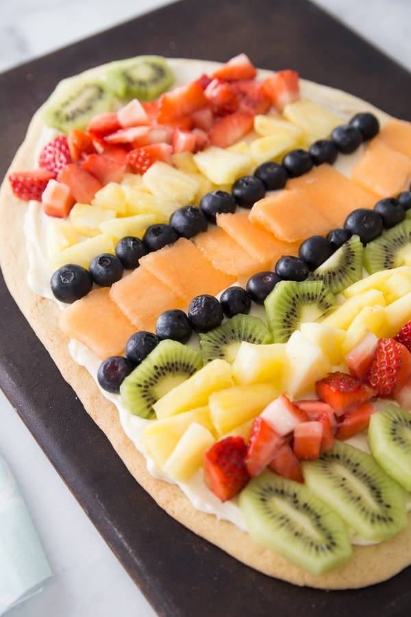 EASY Easter Egg fruit pizza is a must make. A sugar cookie crust that has a layer of cream cheese frosting, and topped with fresh fruit. #easter #dessert #easy #freshfruit #sugarcookie #creamcheese #fruitpizza easy fruit pizza recipe