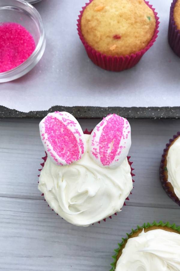 This Easter bunny cupcake idea is perfect for kids. Funfetti cupcake with frosting, and decorated with marshmallows, candy eyes and more. #easter #dessert #kidfriendly #easy #cupcakes #funfetti #marshmallow #candyeyes how to make bunny cupcakes