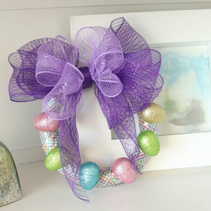 This Dollar Tree DIY Easter Wreath is so simple to make and affordable. It will be the perfect way to decorate your front door, or gift to a loved one! #Easter #craft #easy #ribbon #mesh #easteregg #DollarTree #affordable #quick #easterwreath Easter Wreath