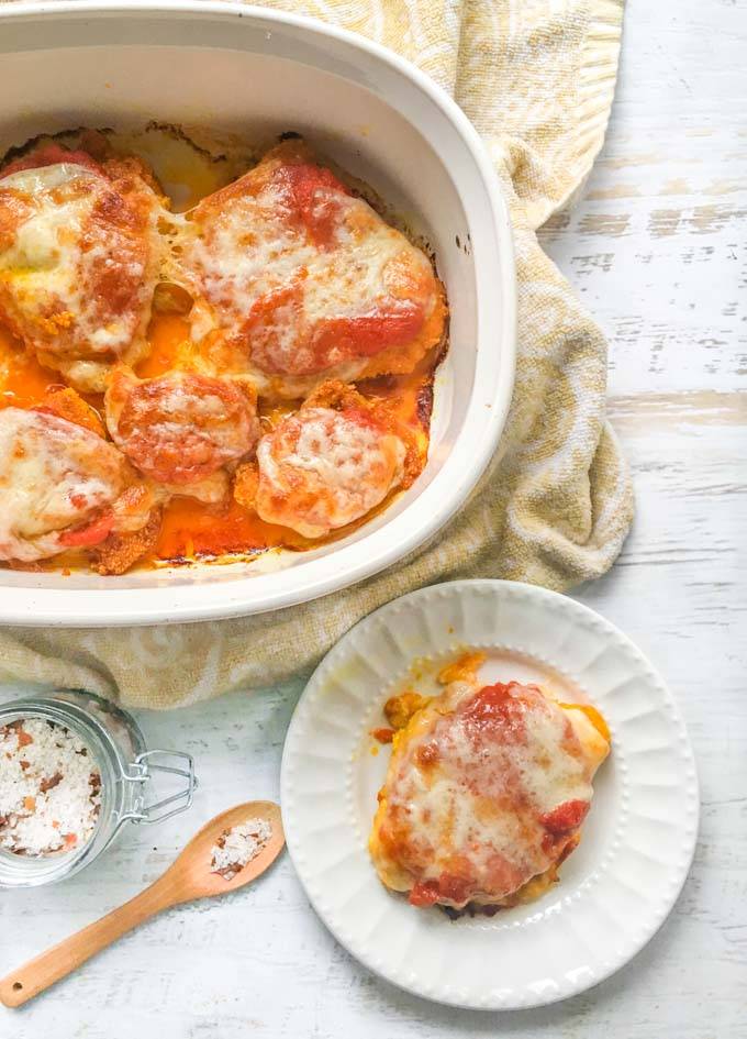 low carb chicken parmesan on a plate with casserole dish in the background