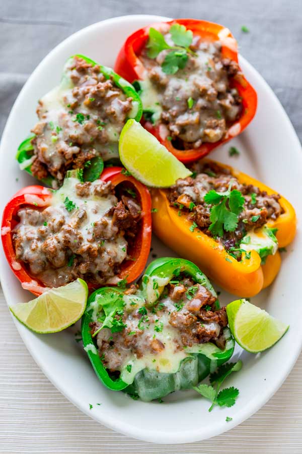 stuffed mexican peppers on a white plate with lime wedges 