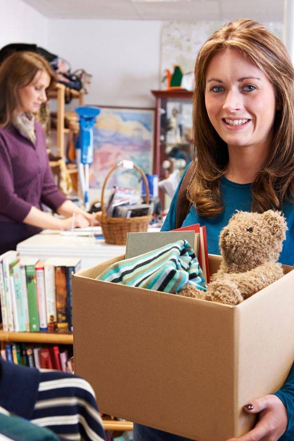 women dropping stuff off at thift store in box