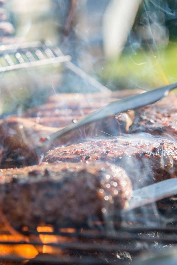 hamburgers being cooked on a grill