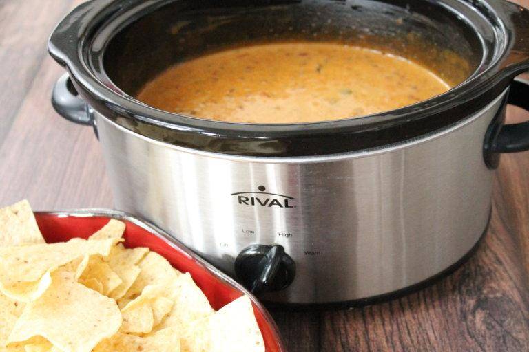 crockpot queso with bowl of chips by it