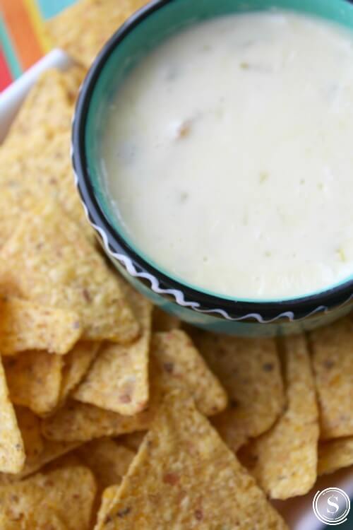 white cheese dip in a bowl with chips by it