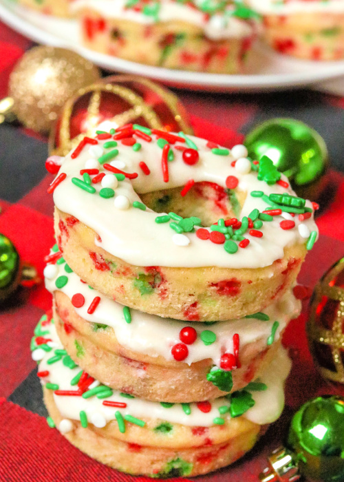 three christmas confetti donuts with sprinkles on top stacked on top of each other