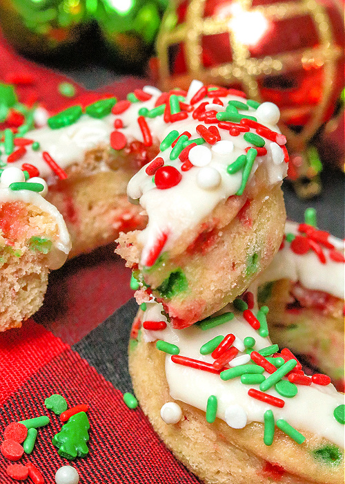 a baked christmas confetti donut with a bite taken out of it