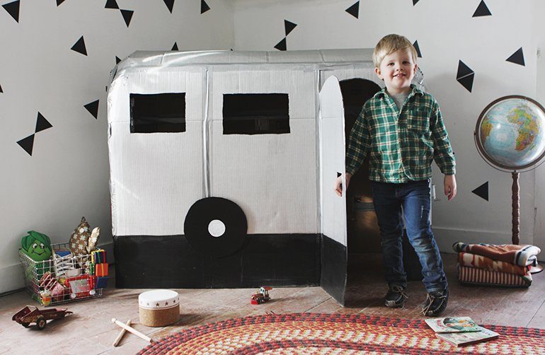 cardboard camper with kid by it 