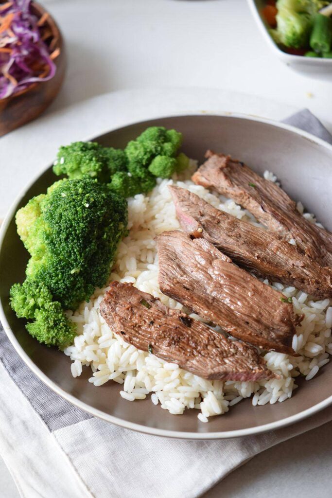 steak in a bowl with rice and broccoli