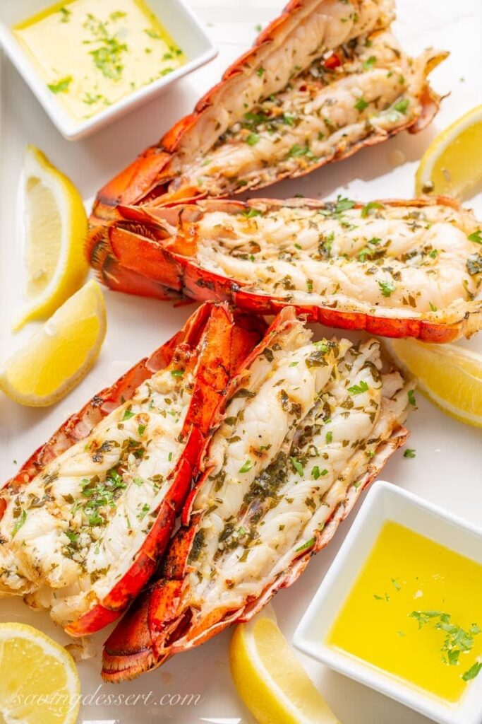 grilled lobster tails on a plate with butter by it 