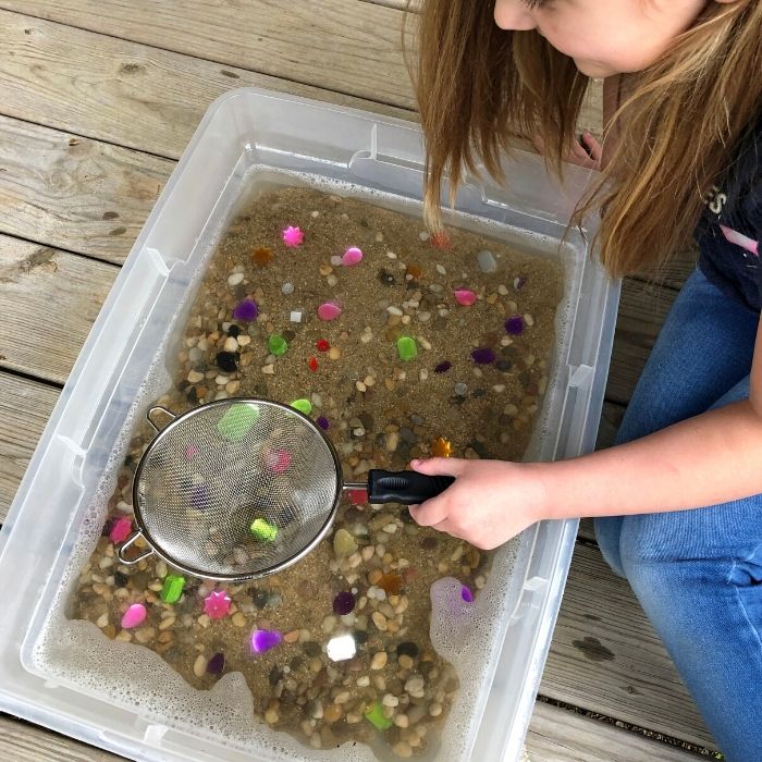 little girl panning for gems and rocks 