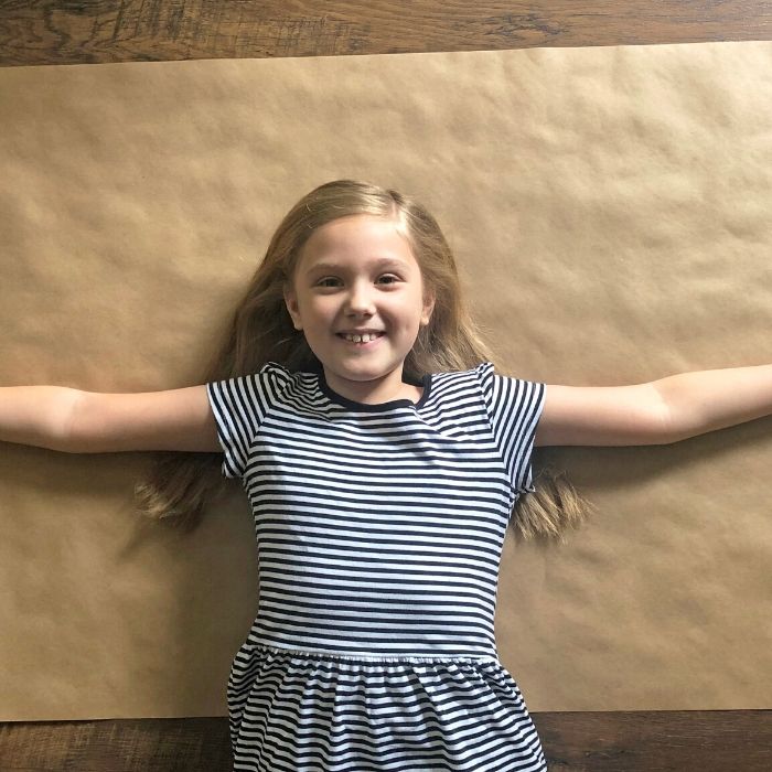 girl laying on floor with brown paper under her