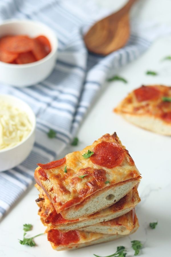 French Bread Pepperoni Pizza is an affordable and quick way to serve up pizza for dinner. Grab that French bread loaf and then pile on the sauce, cheese, and your favorite toppings. #pizza #frenchbread #easy #weeknight #dinner #pizzadinner #pepperoni #sauce kid friendly dinner idea