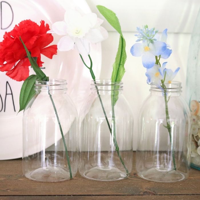 red, white, and blue flowers in a glass bottle 