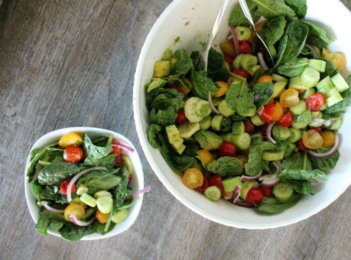 cucubmer tomato salad in a bowl with a big bowl by it 