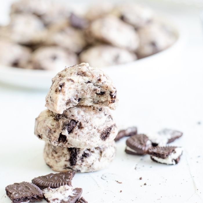 Cookies and Cream Cookies are the ultimate cookie recipe for cookie lovers! If you love Hershey's cookie and cream candy bar, you will love these cookies. #cookies #cookiesandcream #dessert #oreo #creamcheese #bakesale #cookieswap #dessertrecipe stacked cookies on a white table
