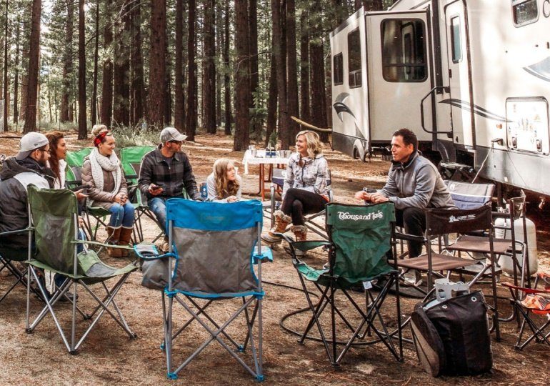 How to Rent an RV with RVShare - People sitting at campsite with RV