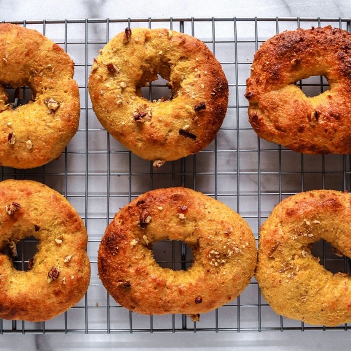 Keto Pumpkin Pecan Bagels are a homemade keto bagel that has a nice flavor of pumpkin in every bite. The ultimate keto breakfast recipe! #passion4savings #keto #pumpkin #Pumpkinspice #bagel #almondflour #easy #best #breakfast keto bagels on a cooling rack on table