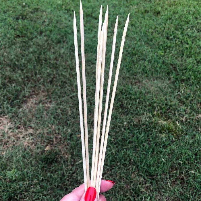 holding wooden skewers 