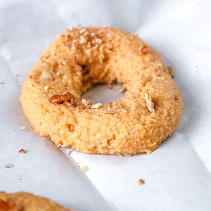 Keto Pumpkin Pecan Bagels are a homemade keto bagel that has a nice flavor of pumpkin in every bite. The ultimate keto breakfast recipe! #passion4savings #keto #pumpkin #Pumpkinspice #bagel #almondflour #easy #best #breakfast pumpkin spice keto bagels on parchment paper