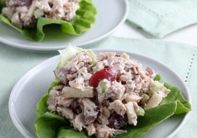 chicken salad sandwich on a plat with lettuce leaf