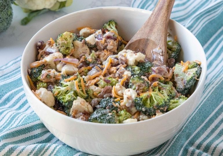 broccoli salad in a bowl with wooden spoon