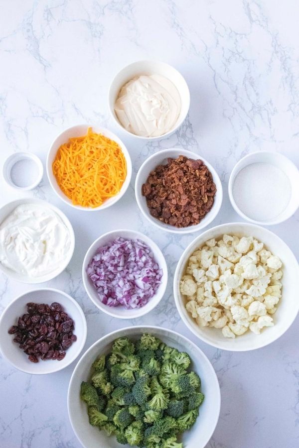Broccoli Cauliflower Salad is the ultimate side dish or potluck dish. Broccoli, cauliflower, cranberries all mixed in a creamy and sweet sauce. #broccoli #cauliflower #easy #sidedish #holiday #Potluck #passion4savings #creamysauce #Homemade #fresh #vegetables broccoli cauliflower salad ingredients in bowls