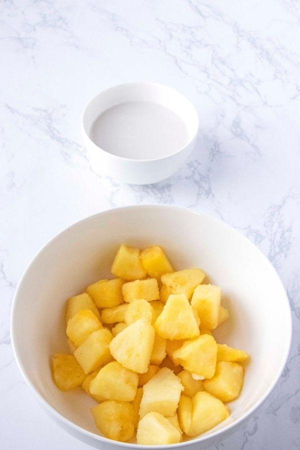 pineapple and a bowl of coconut milk