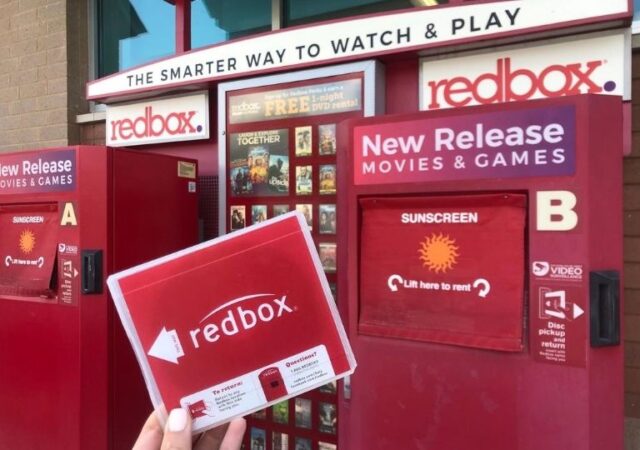 Redbox Movie Rental Codes - holding movie in front of kiosk