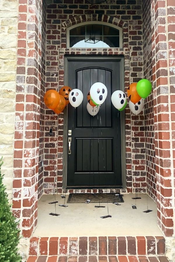 halloween balloons on a porch with candy attached 