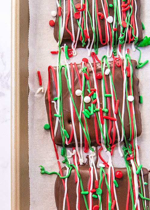 chocolate dipped graham crackers for christmas on a baking sheet