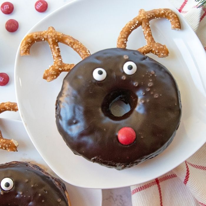 Serve up these Reindeer Donuts that are created from store bought donuts. An easy and fun Christmas donut recipe that is festive and delicious! #donut #christmas #fun #holiday #passion4savings #creative #storeboughtdonuts #breakfast #reindeer reindeer donut on plate