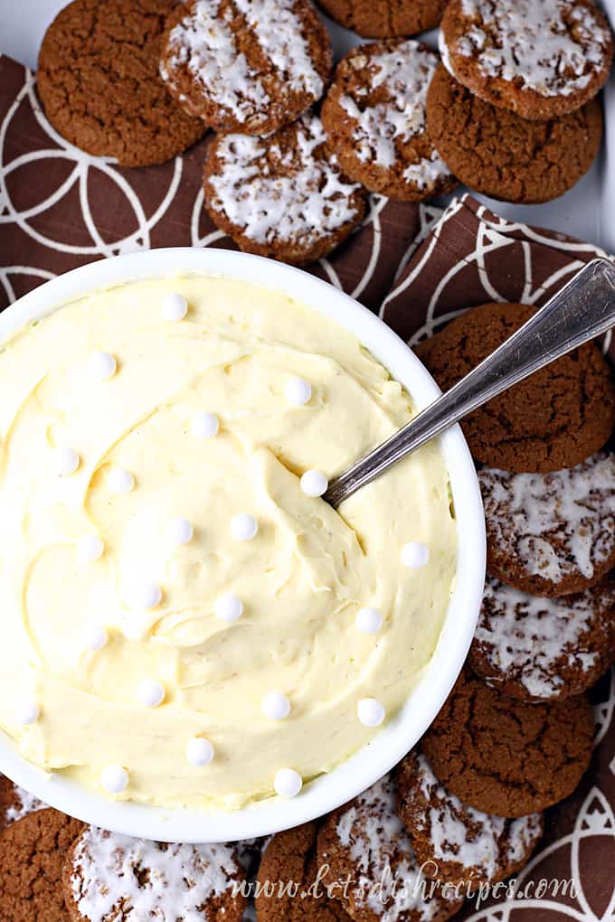 eggnog dip with spoon in bowl and cookies around it 