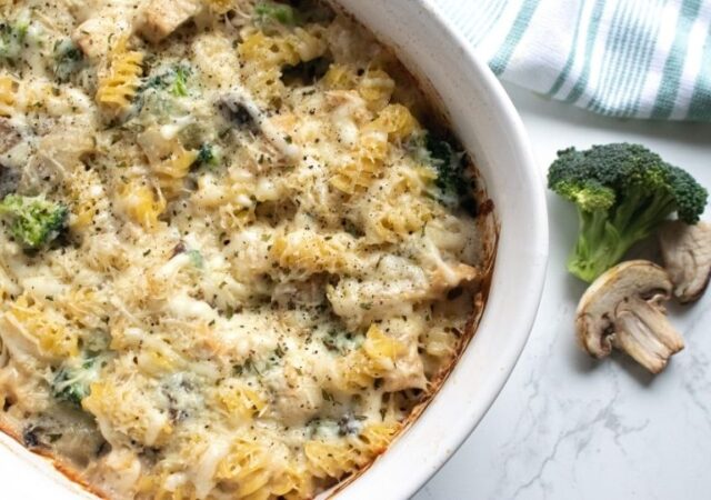 Broccoli Chicken Casserole in a pan with broccoli floret by it