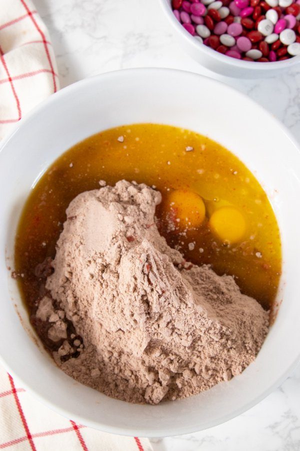 Red Velvet Cake Mix Cookie Bars are a 4 ingredient cake mix cookie bar -perfect for Valentine's Day. Give this easy vday dessert a try! #vday #passion4saving #cakemix #cookiebars #cookies #recipe #forkids #easy #quick #dessert #best cake mix batter in bowl with eggs