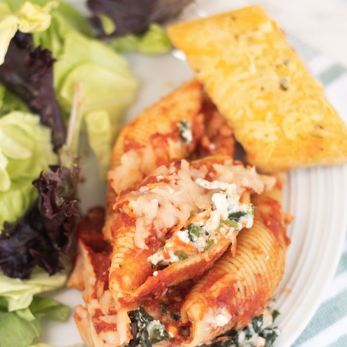 plate with salad, stuffed shells, and garlic bread 