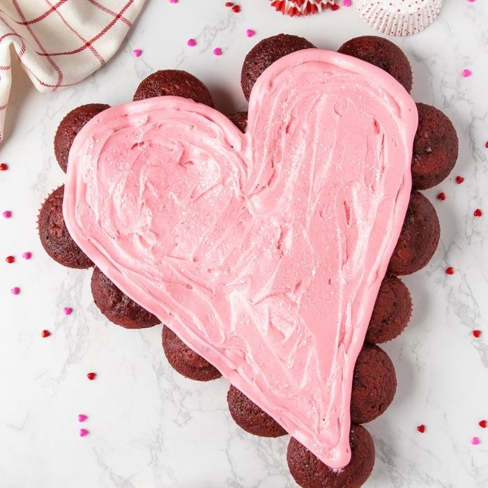 heart shaped cupcake cake with frosting spread on the top 