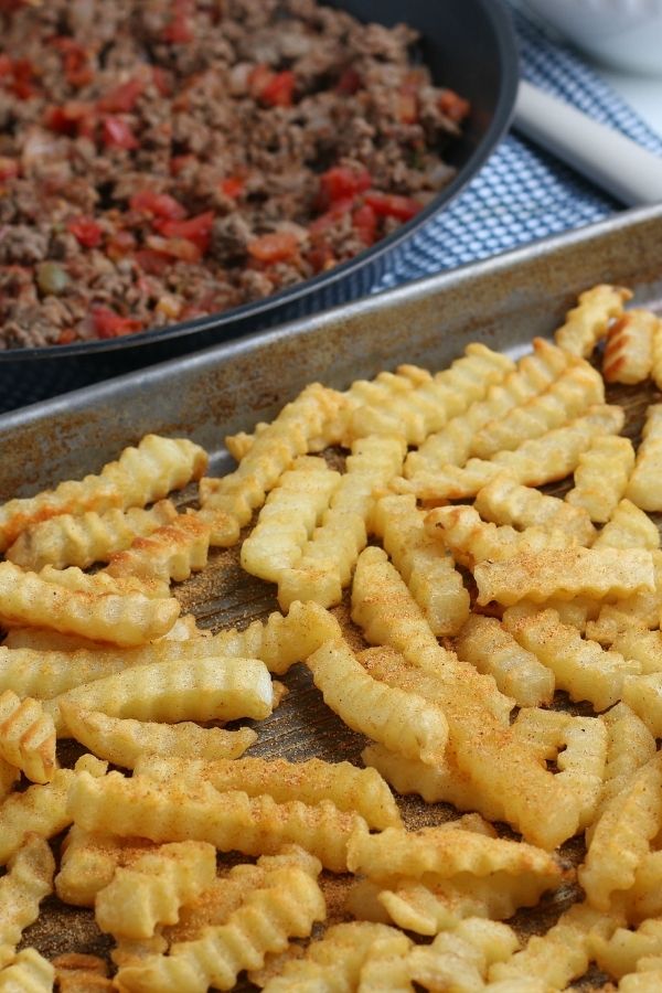 french fries on pan with beef in skillet behind it 