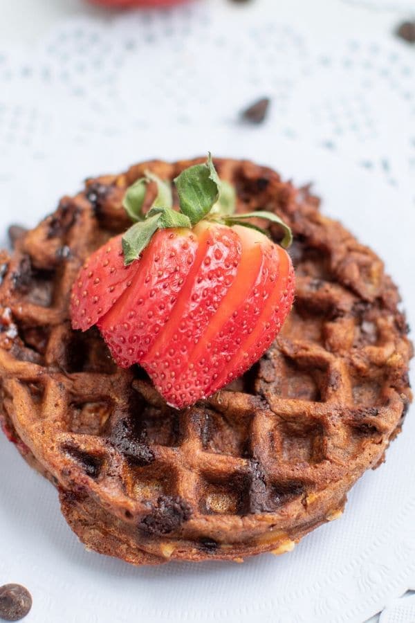Check out these tasty recipes in waffle maker! From sweet to savory and all things in between. Whip up these for snacks, lunch or dinner. #passion4savings #waffle #wafflemaker #savory #sweet #dessert #best #easy chocoalte keto chaffle on plate with strawberry