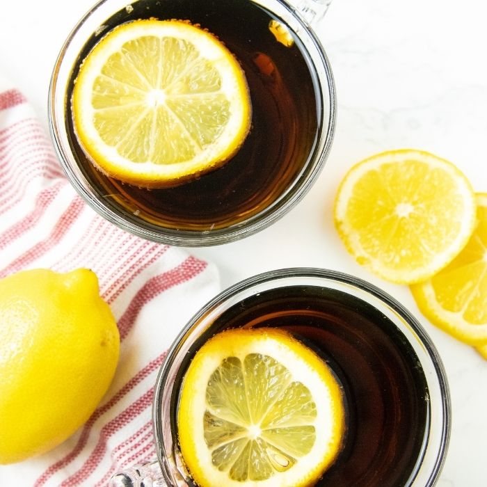 warm dr pepper in cups with lemon slices in them 